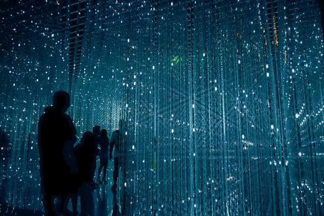 image of a person standing in front of points of light